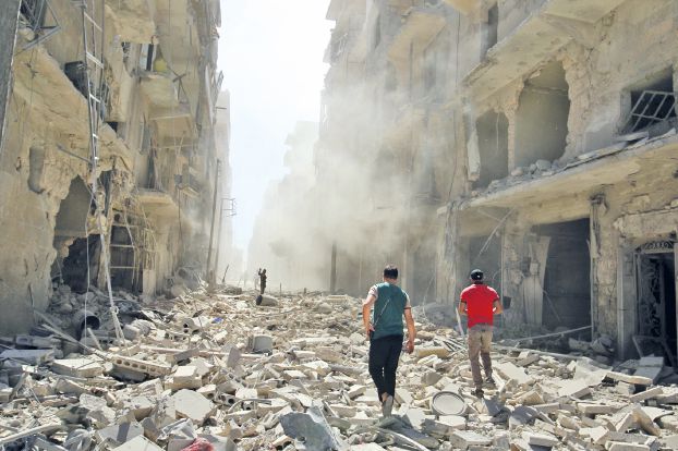 Men inspect the damage after an airstrike on the rebel held al-Qaterji neighbourhood of Aleppo